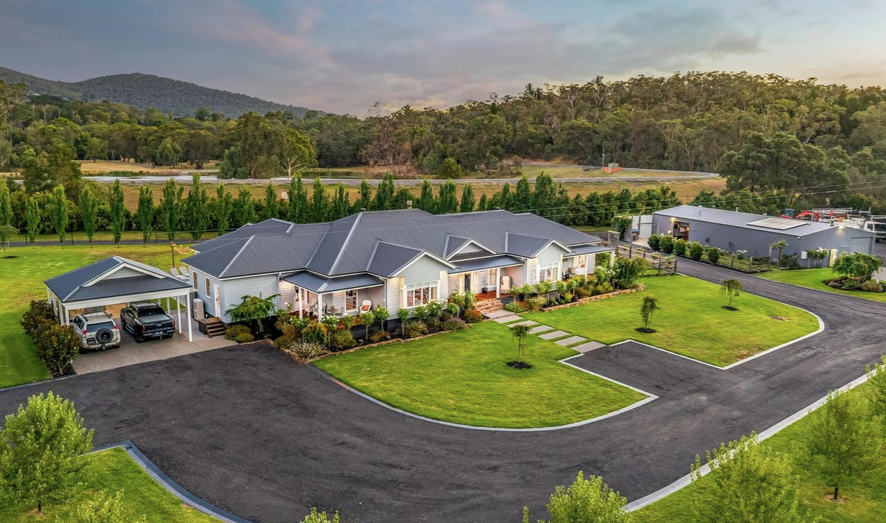 Row of single-story ranch-style homes with gray roofs and manicured lawns along a curved cul-de-sac